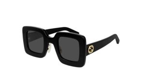 Gucci 0780/s sunglasses have a strict square line while the golden logo contrasts with the black frame.